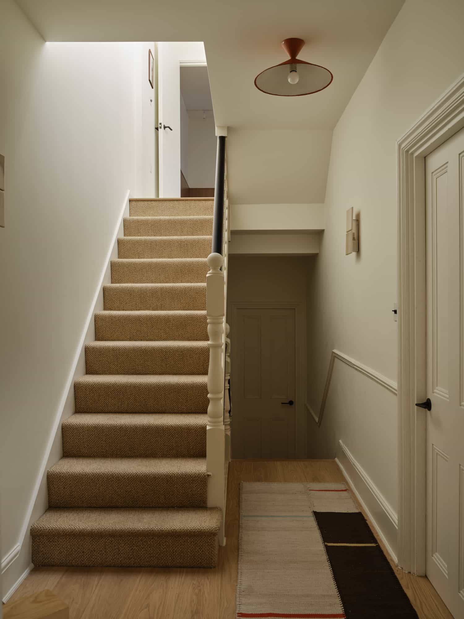 Love Locations minimalist hallway location SE23: Clean, contemporary white staircase featuring light oak steps and simple structural lines, optimized for film tracking shots.