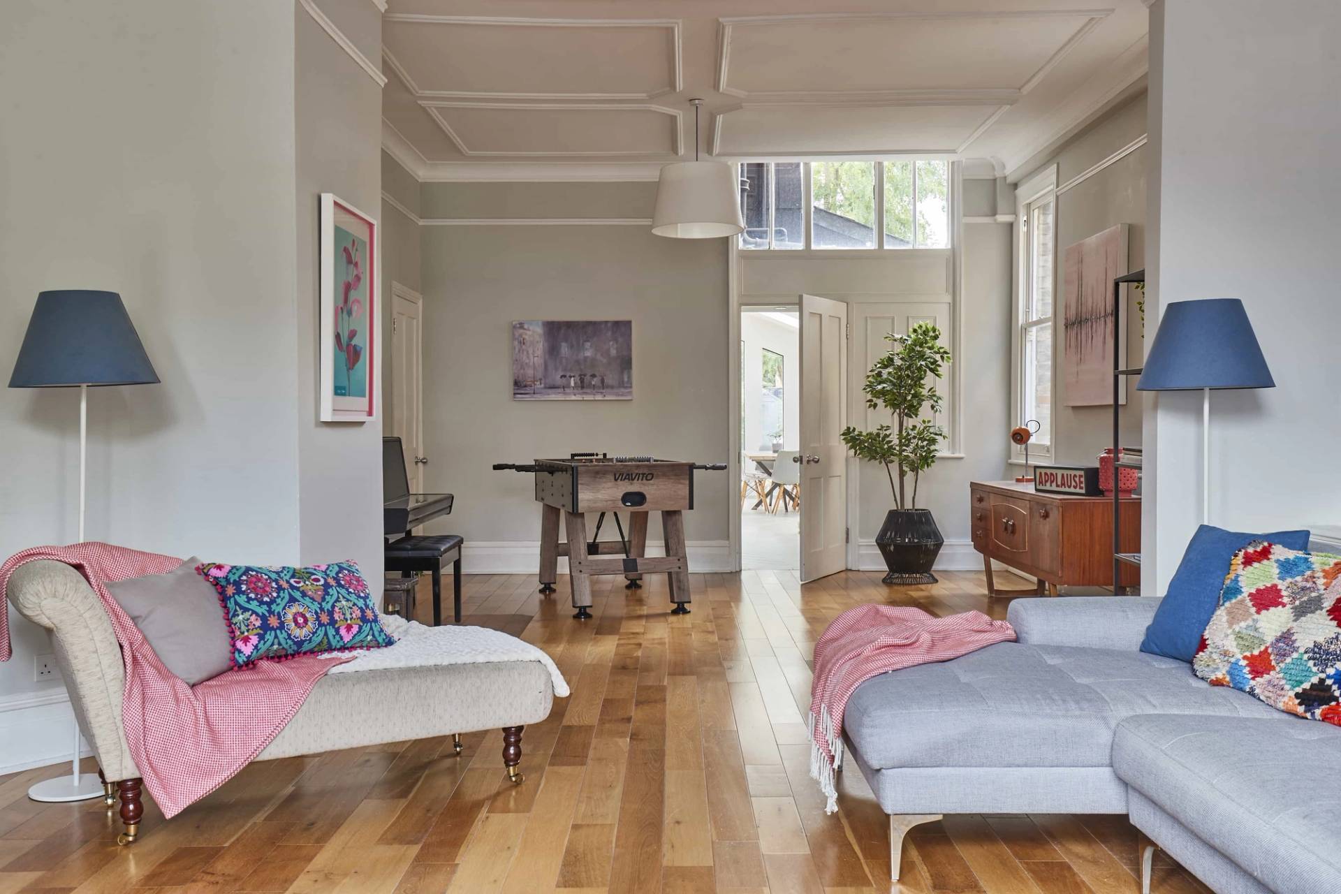 Light-filled double reception room looking through toward hallway entrance with period architraves and polished wooden floors, Love Locations W3.