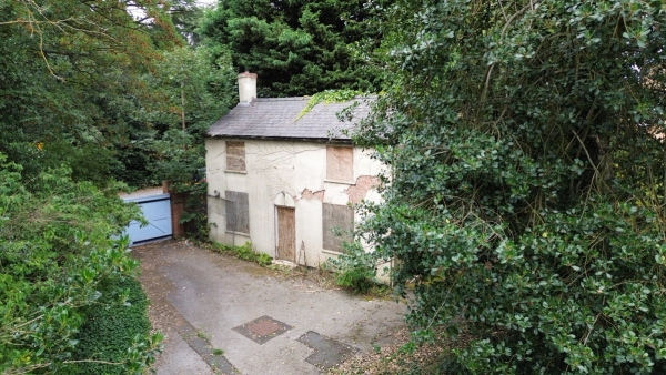 High-angle view of a derelict boarded-up Victorian cottage surrounded by overgrown trees in Beeston, Nottingham, NG9, available for spooky film shoots via Love Locations.