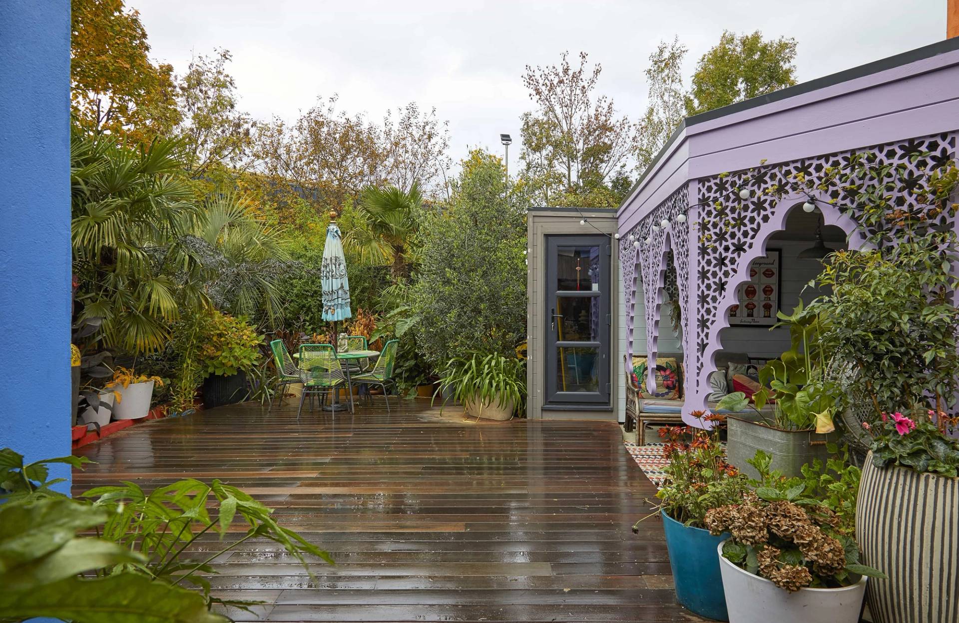 Spacious outdoor timber garden deck featuring a carved purple decorative veranda arch structure, Love Locations SE6.