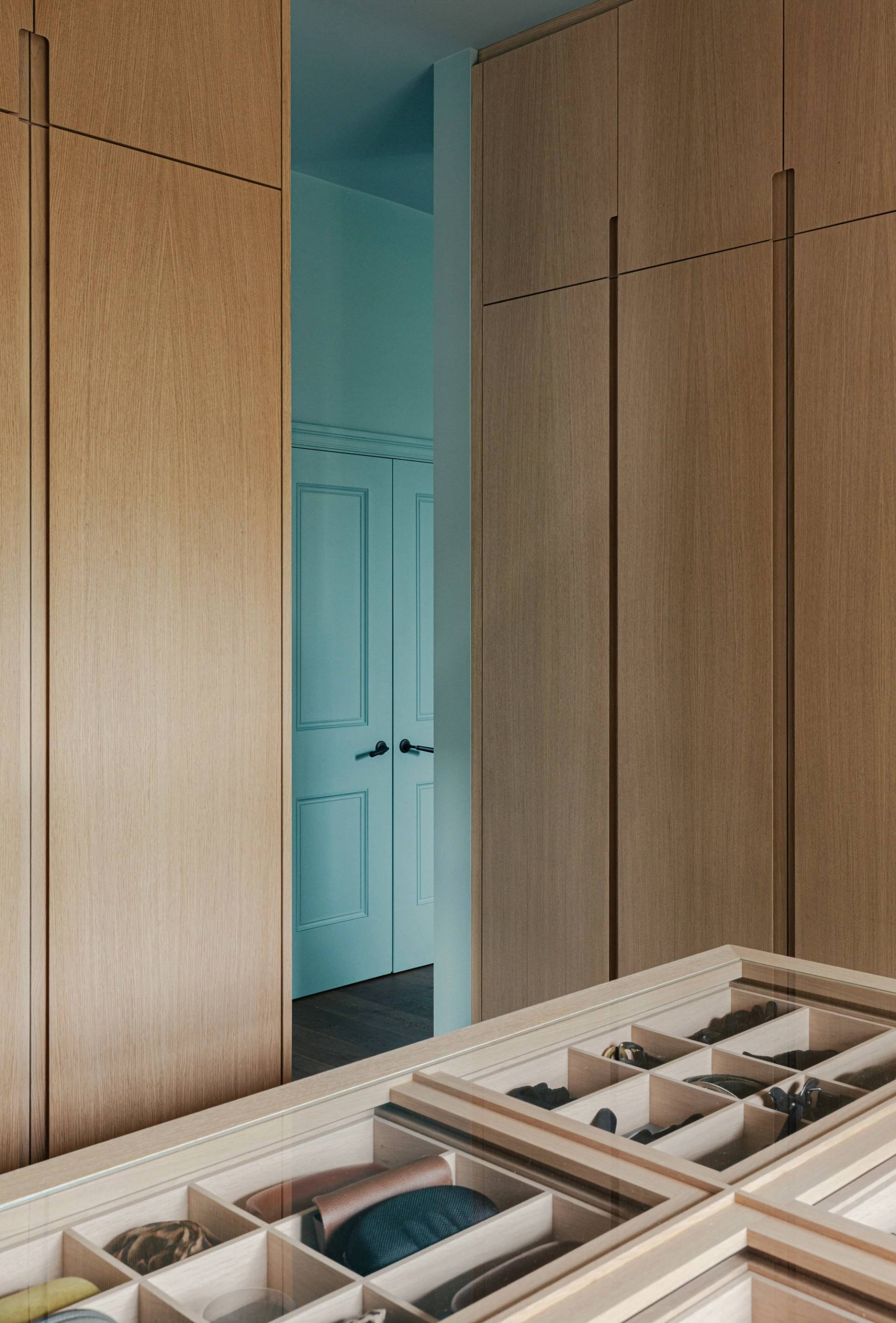 Oak dressing room doorway transition looking into a soft teal painted room, Love Locations SW13.