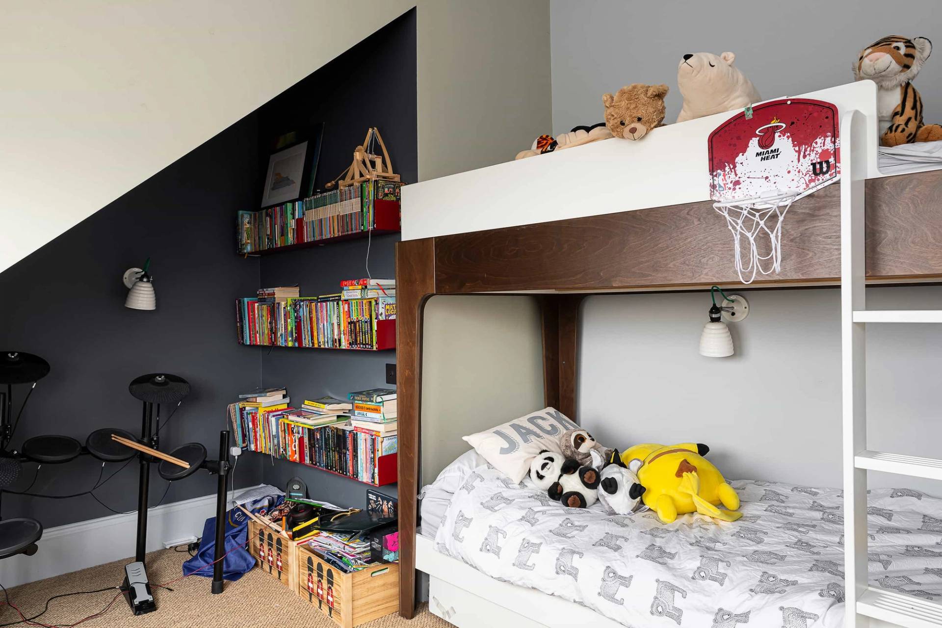 Kids bunk room featuring a dark wood bunk bed frame, sloped ceilings, and built-in book shelves, ideal for family brand campaigns, Love Locations.