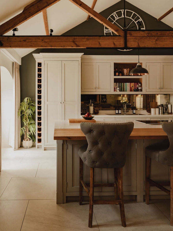 Shaker-style kitchen island featuring upholstered bar stools and marble worktops inside a converted barn location, suitable for culinary commercial productions, Love Locations.