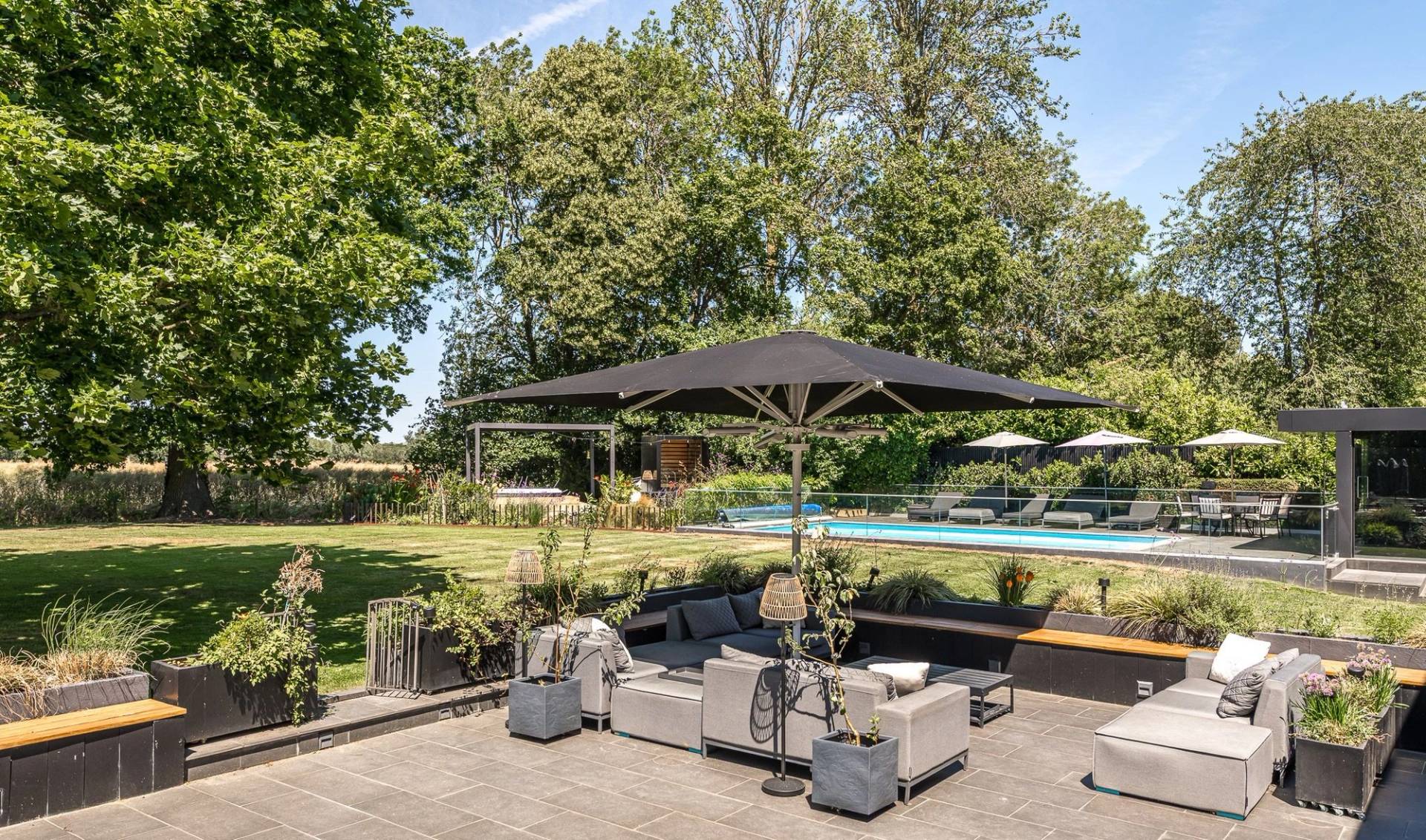 Al fresco garden dining patio setup overlooking a luxury private swimming pool area, ideal for summer brand campaigns, Love Locations.