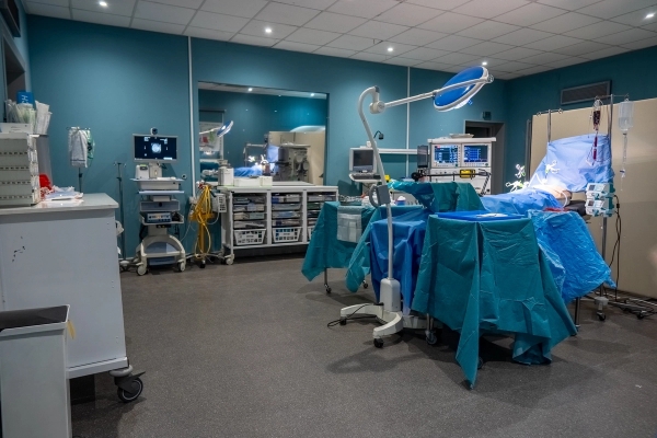 Medical surgery room featuring surgical lamps, draped operating table, and anesthesia equipment, Love Locations UB4.