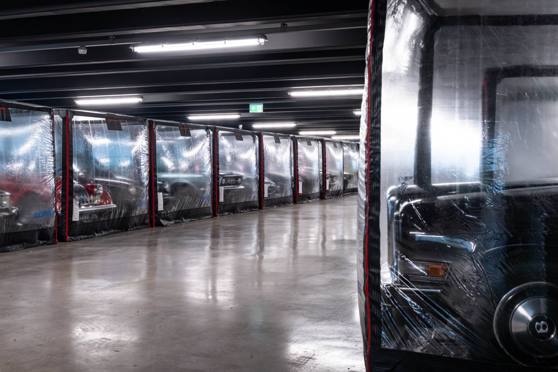 Angled view of luxury car storage pods lining a polished concrete floor in Brentford via Love Locations.