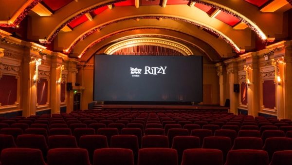 Symmetrical view looking toward the massive cinema projection screen inside The Ritzy Screen 1 film location in Brixton SW2 from Love Locations.