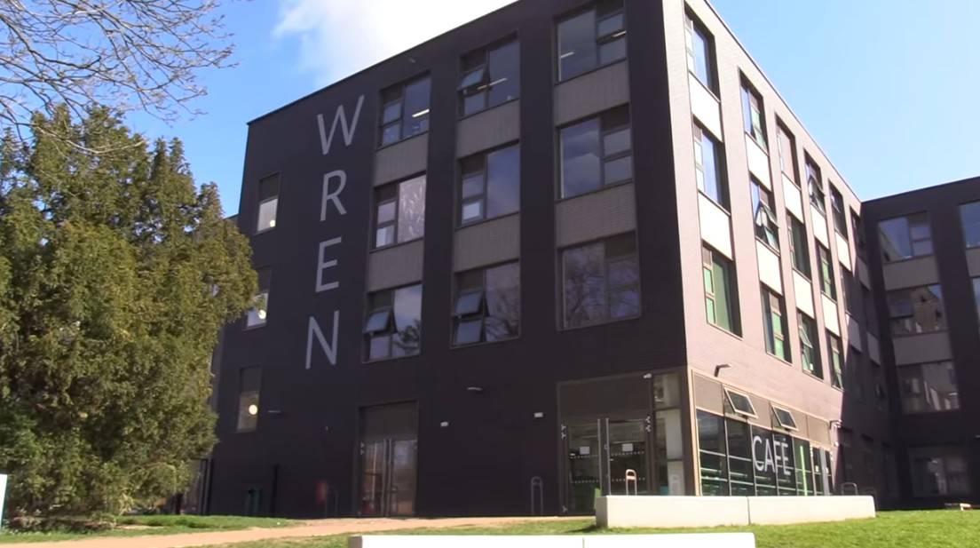 Love Locations modern school building exterior Reading RG30: Contemporary dark grey multi-story campus facade with 'WREN' lettering and large windows, ideal for institutional establishing shots.