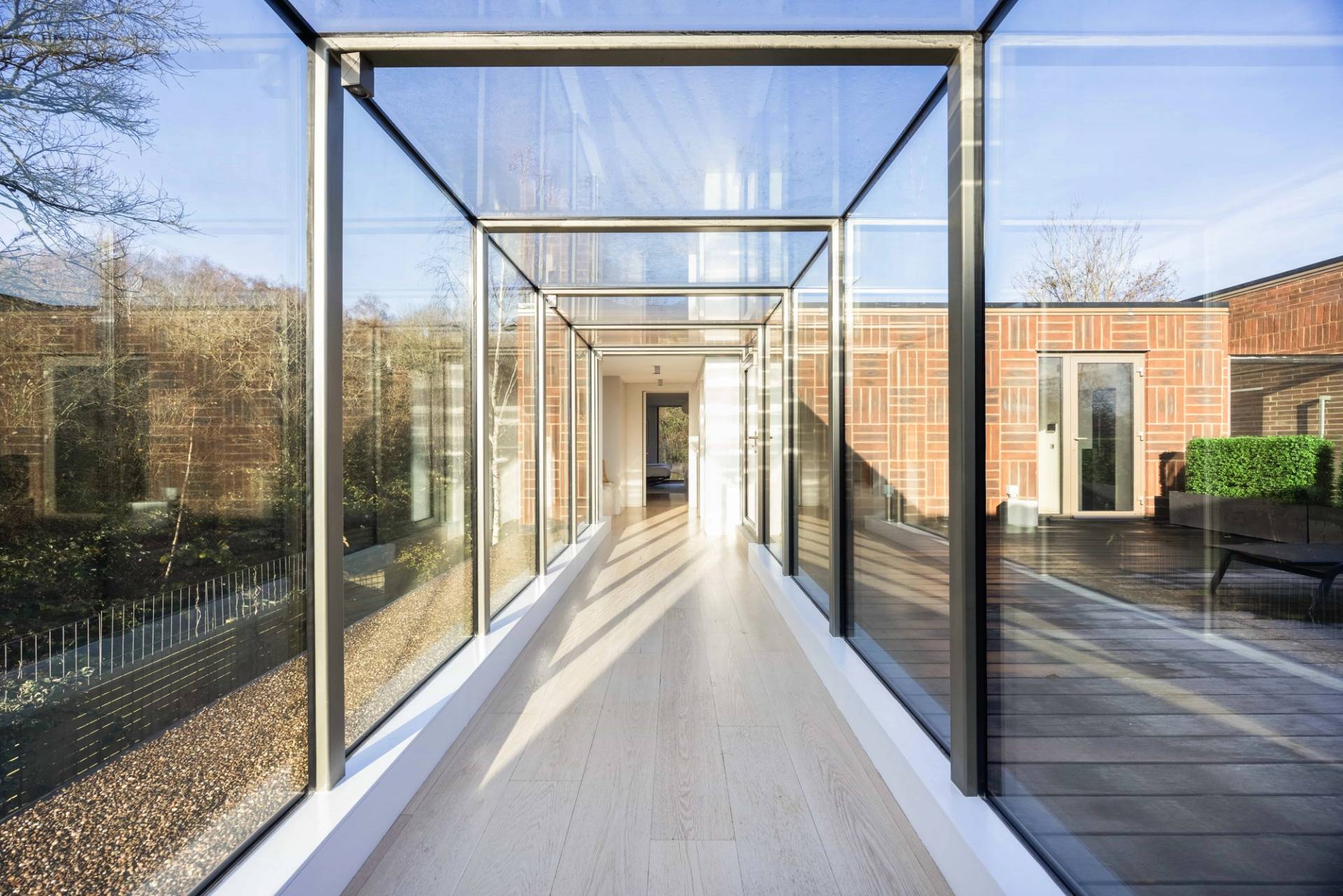 Glass bridge corridor connecting upper floor suites in a modern architectural mansion, Love Locations WD7.