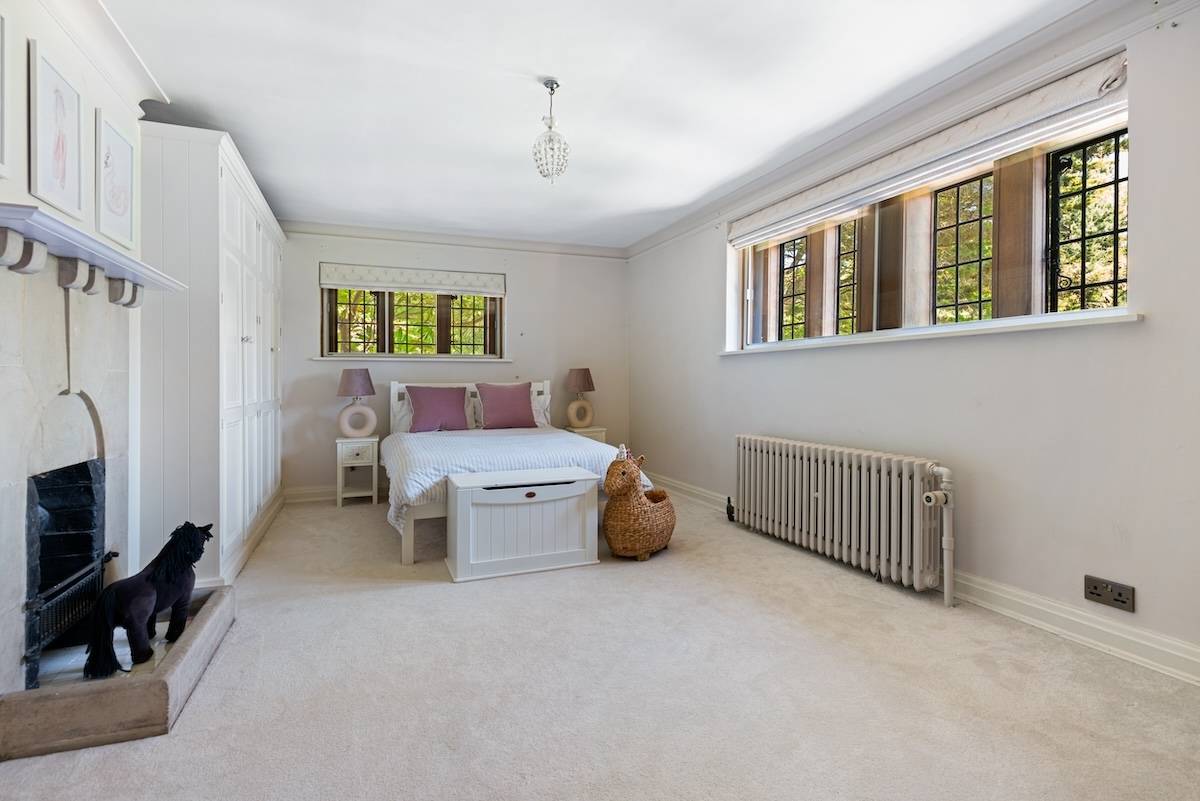 Guest bedroom featuring neutral bedding, traditional cast iron radiator, and leaded window light, Love Locations RH13.