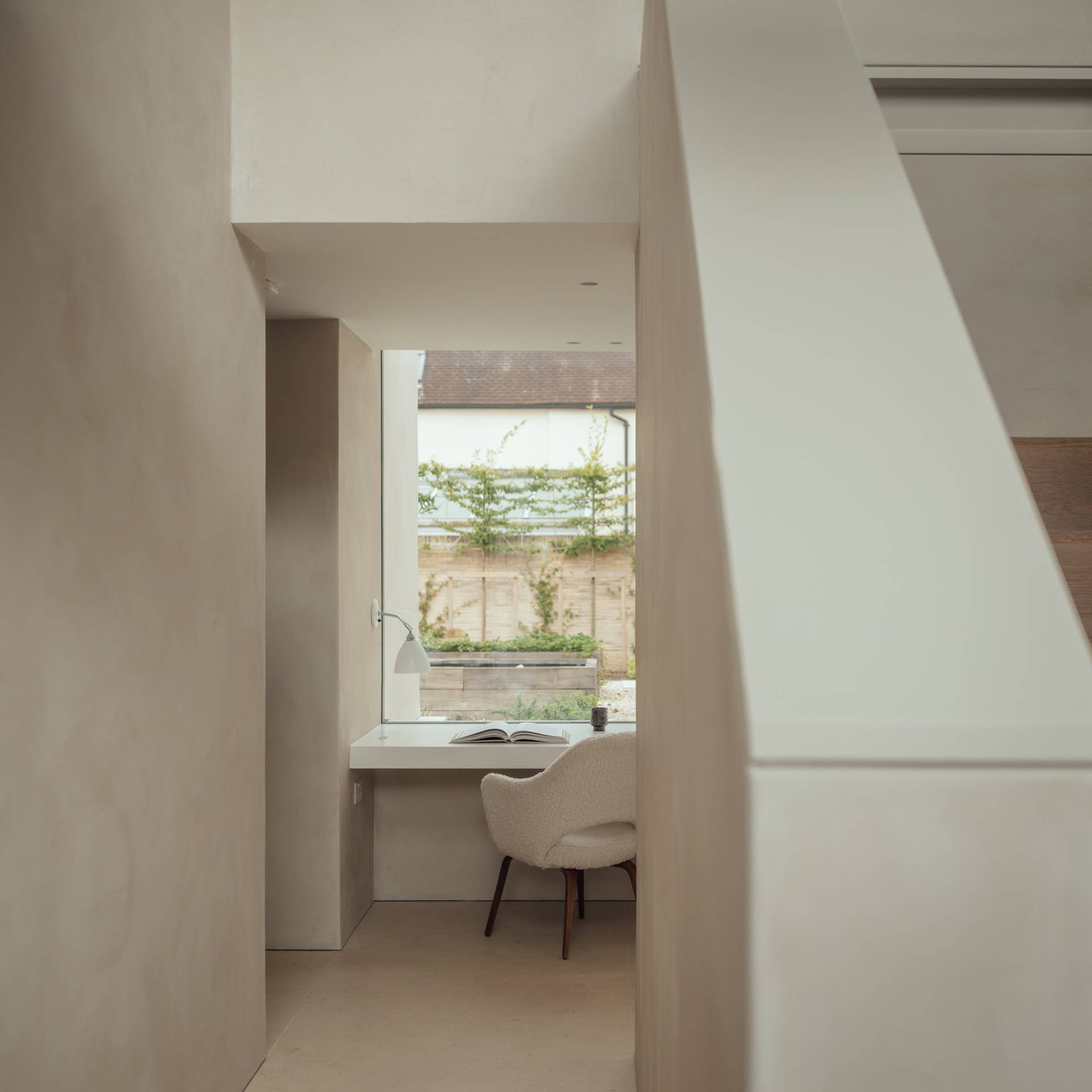 Minimalist dressing nook featuring a built-in white desk setup and curved wall cutouts, Love Locations SO20.