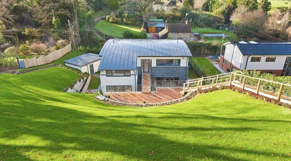 Stunning view looking up a steep green lawn toward a luxury modern architectural location house for premium TV productions, Love Locations.