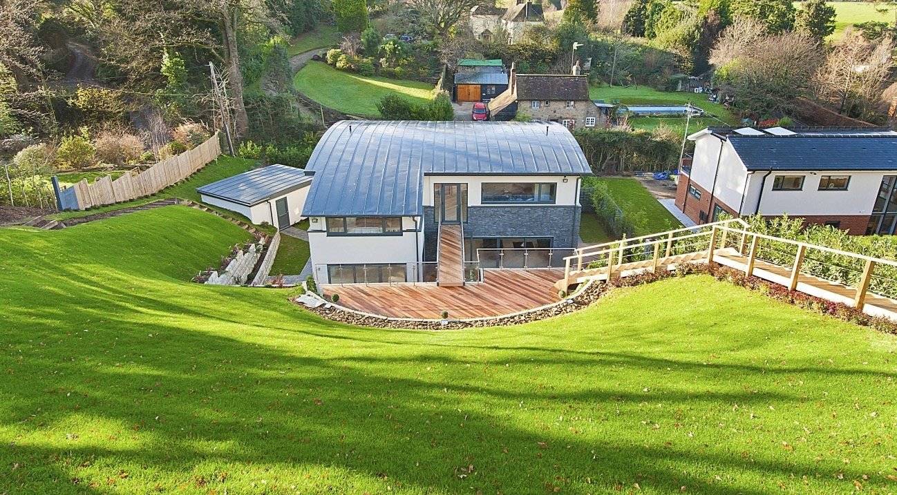 Stunning view looking up a steep green lawn toward a luxury modern architectural location house for premium TV productions, Love Locations.