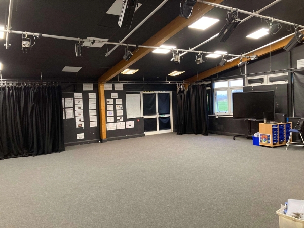 Love Locations performance arts studio Chelmsford Essex CM1: Creative drama space showing an industrial exposed ceiling with stage spotlights and a media television setup, perfect for actor interview sets and music videos.