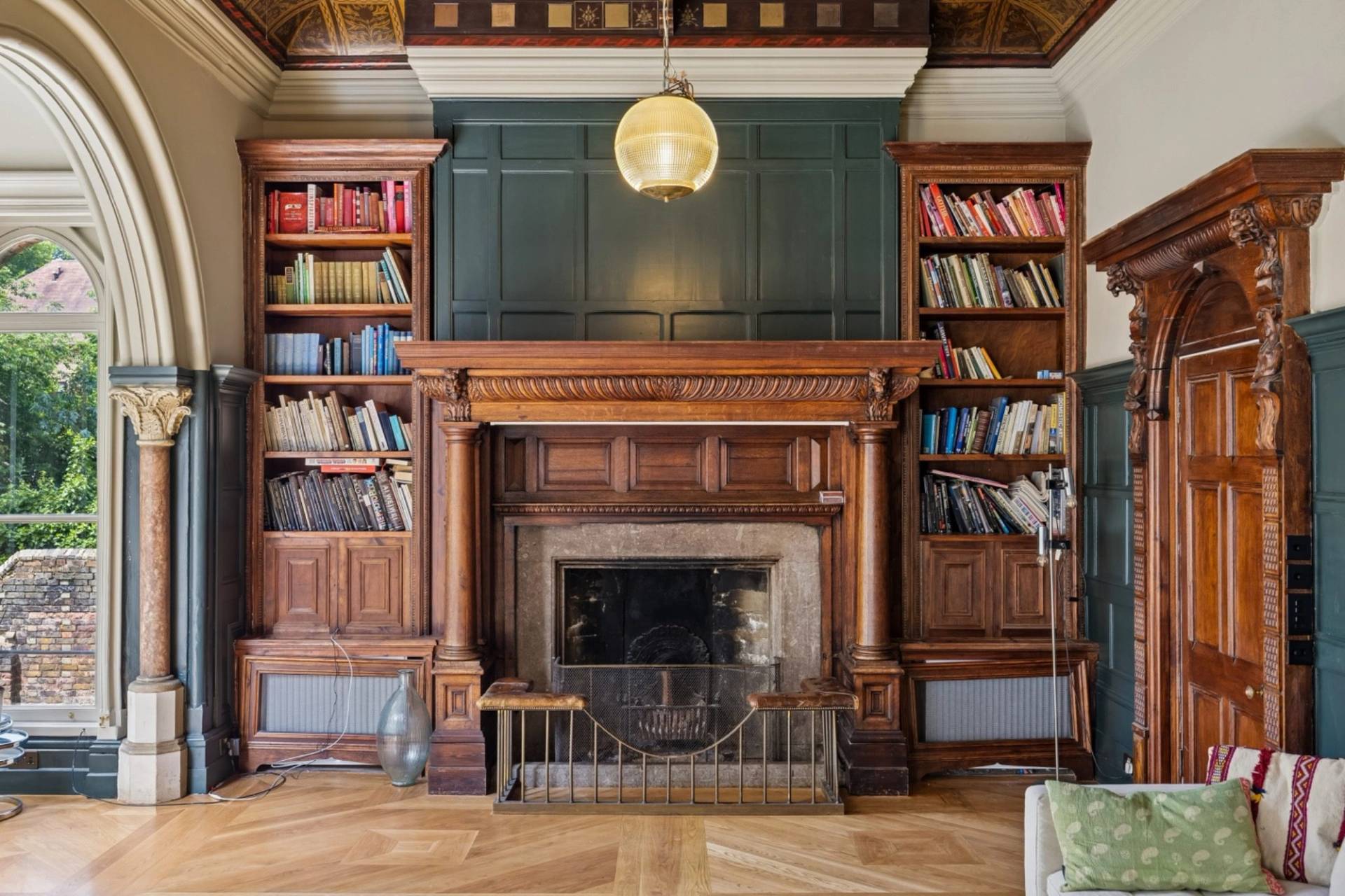 Detailed carved oak fireplace and built-in library bookshelves in a gothic Hampstead location house from Love Locations.