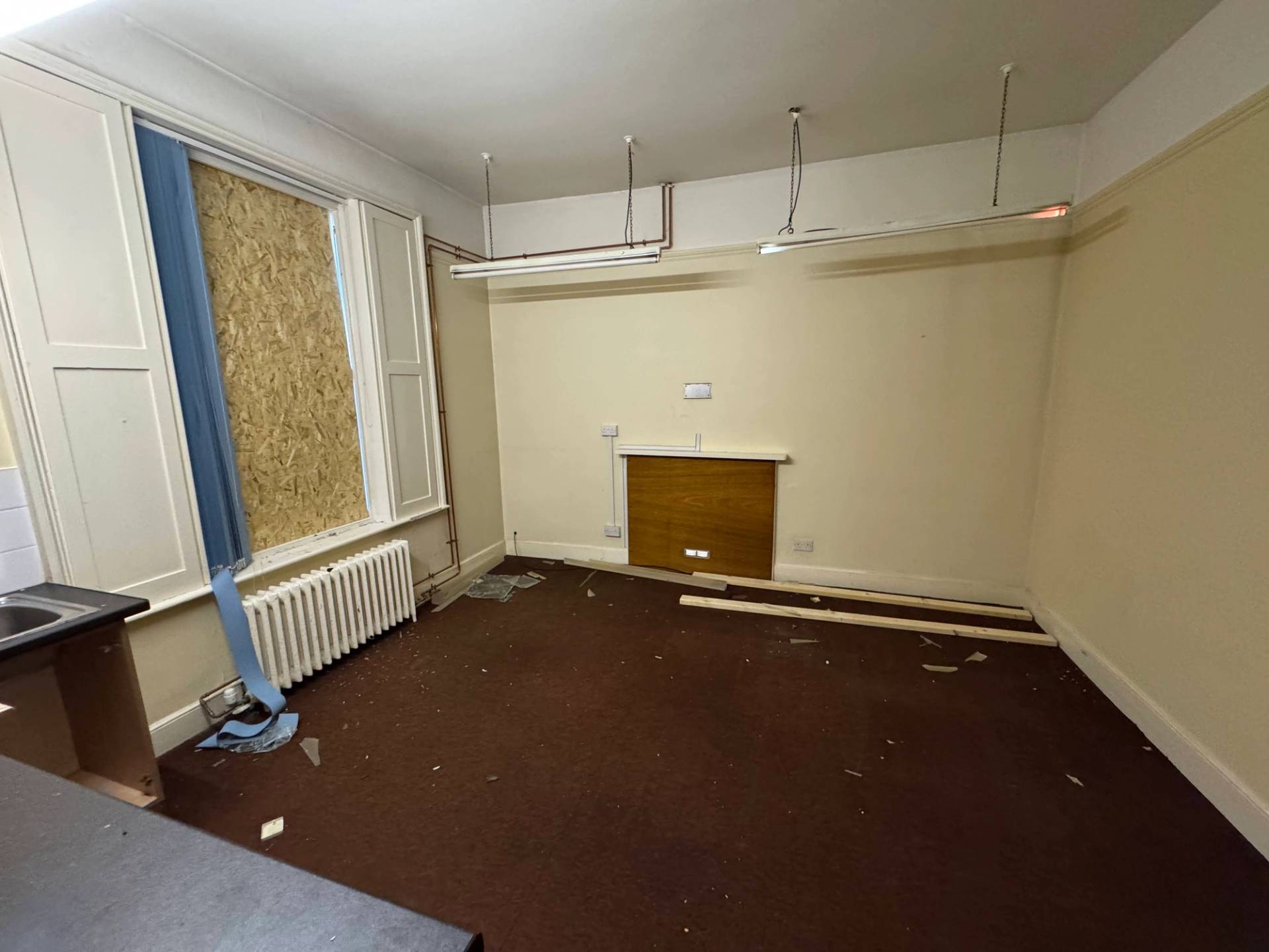 Spacious unmodernised room with a blocked-off period fireplace and weathered beige walls in Beeston, Love Locations NG9.