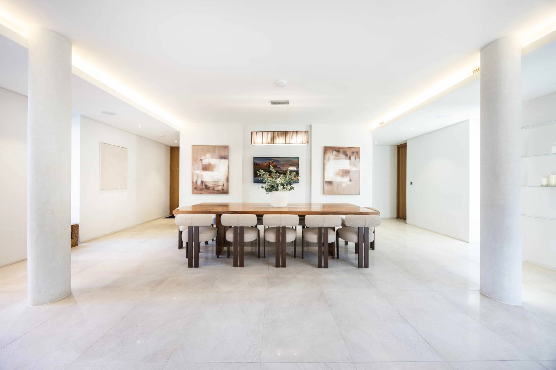Symmetrical shot of a long solid wood dining table set under soft ceiling illumination in Radlett, Love Locations WD7.