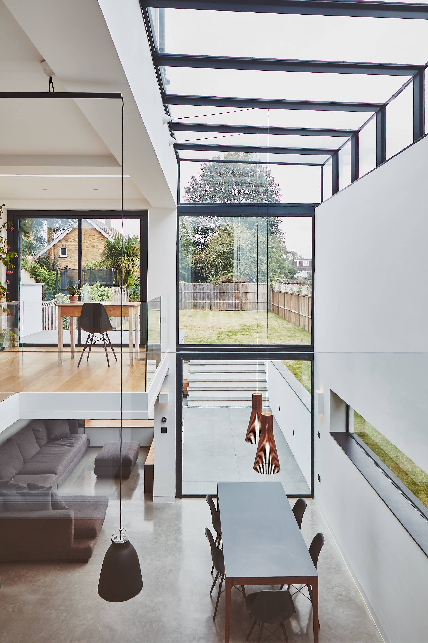 Glass gallery landing with floor-to-ceiling glass windows framing garden light and views, Love Locations TW1.