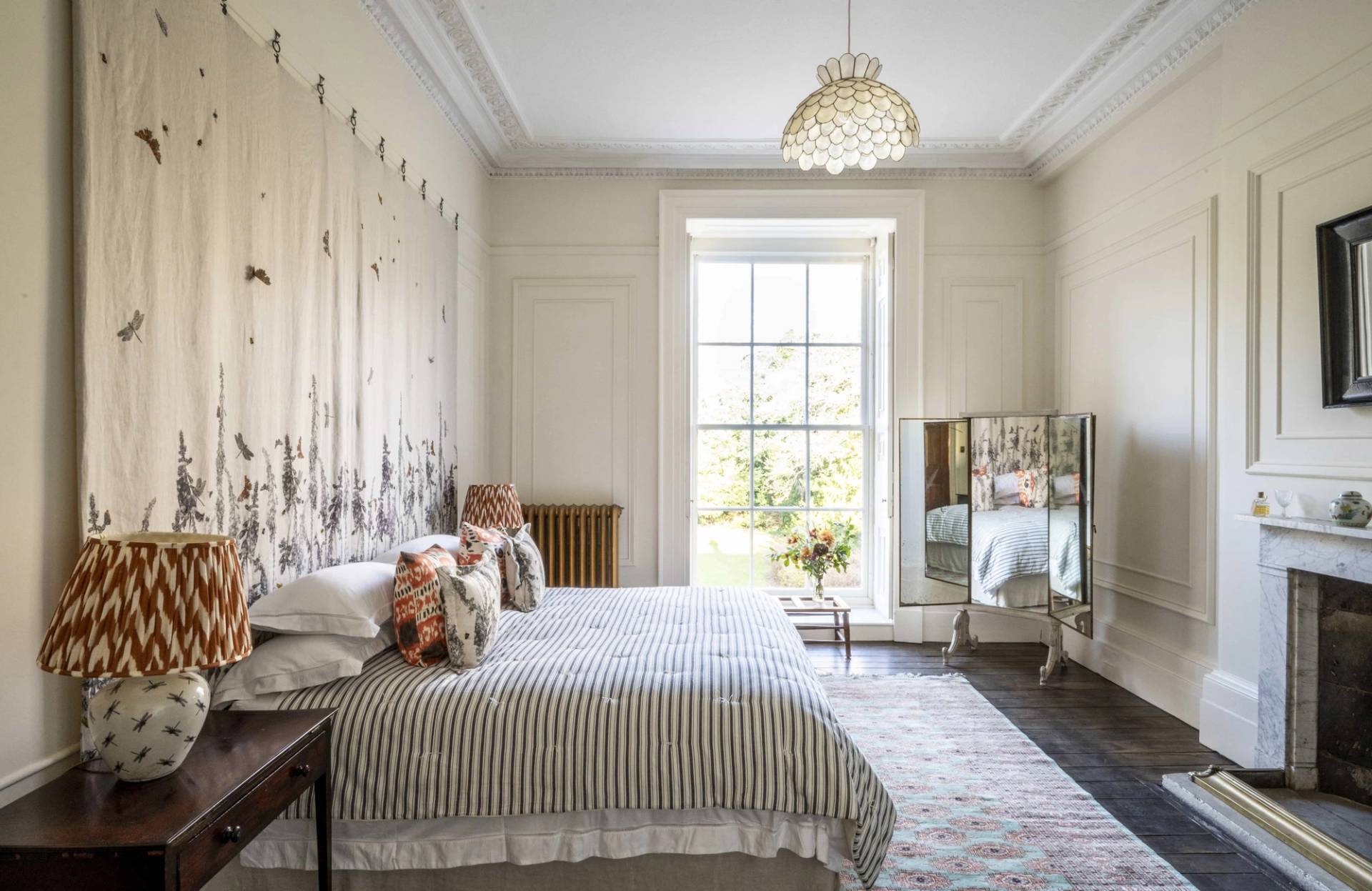 Elegantly styled bedroom showcasing a subtle botanical mural wallpaper feature wall and neutral striped bed linens, ideal for interior design features, Love Locations LE7.