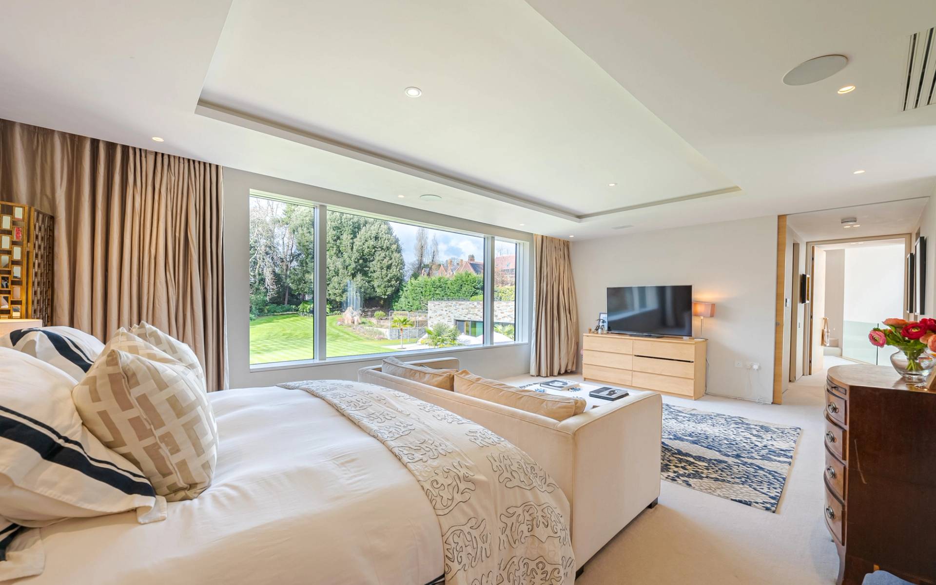 Bright master bedroom with cream upholstered bed, bay window views, and neutral decor in Kingston upon Thames, Love Locations KT2.