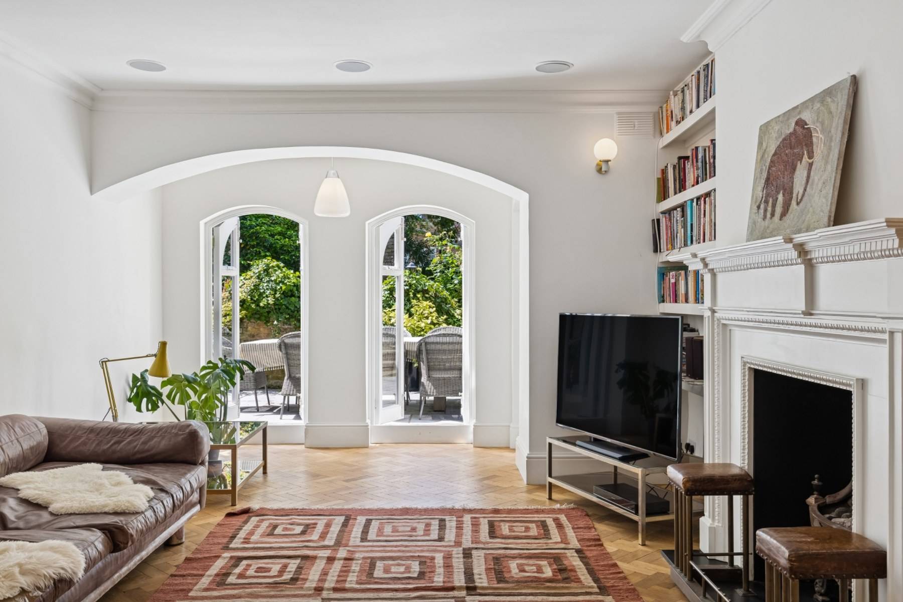 Living room view toward arched French doors in a gothic Hampstead NW3 property from Love Locations.