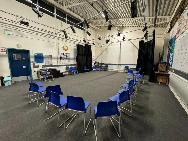 Love Locations drama studio shoot location EN4: Flexible performing arts classroom featuring blue plastic chairs arranged in a discussion circle, perfect for workshop scenes and independent film sets.