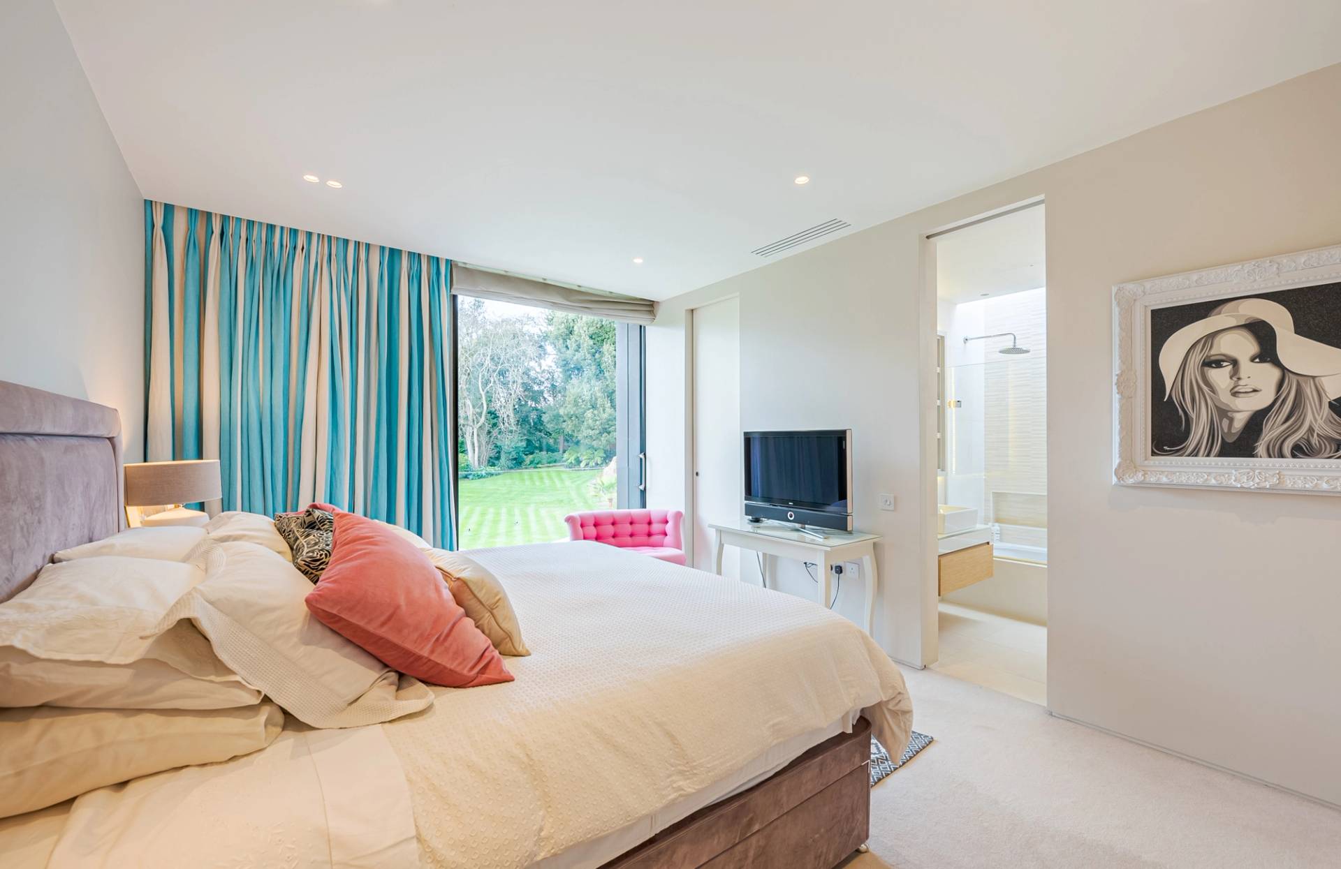Guest bedroom featuring blue curtains, coral throw cushions, and an ensuite bathroom transition, Love Locations KT2.