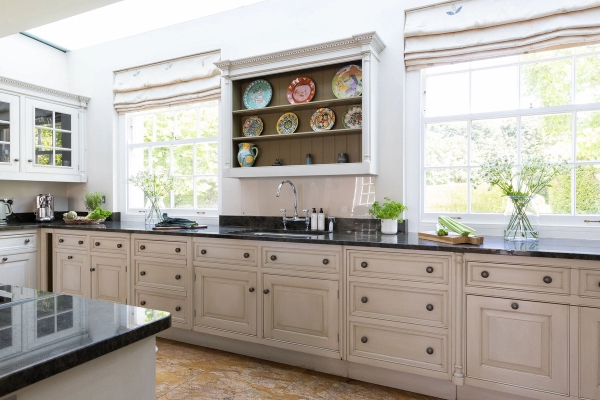 Love Locations elegant larder larder counter West Sussex: Bespoke open shelving displaying decorative plates above a long runs of drawers, ideal for domestic scenes and lifestyle product placement.