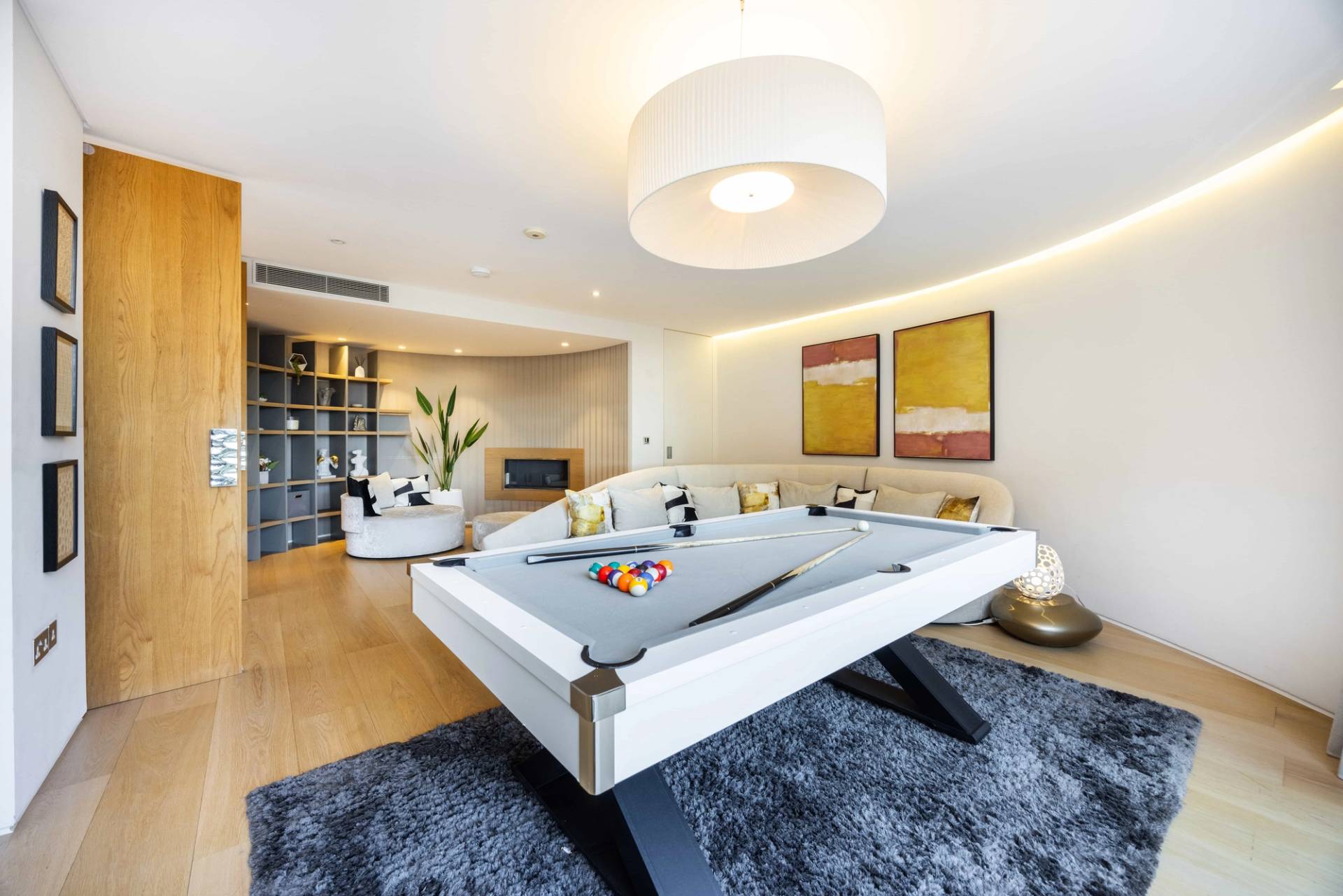 White pool table set under warm pendant lighting in a modern leisure suite, Love Locations WD7.