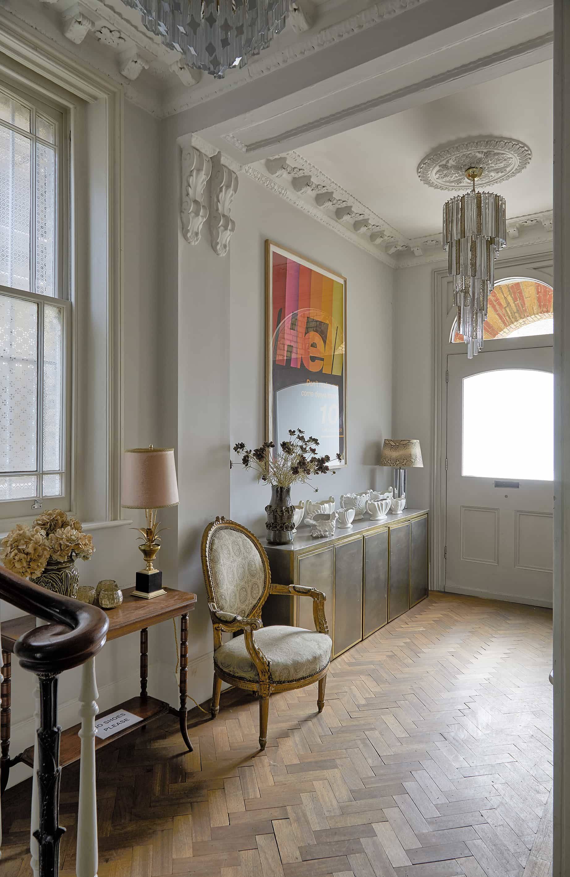 Spacious entrance hallway in Finsbury Park, N16 with brass credenza, french armchair, and yellow pop-art poster, Love Locations.