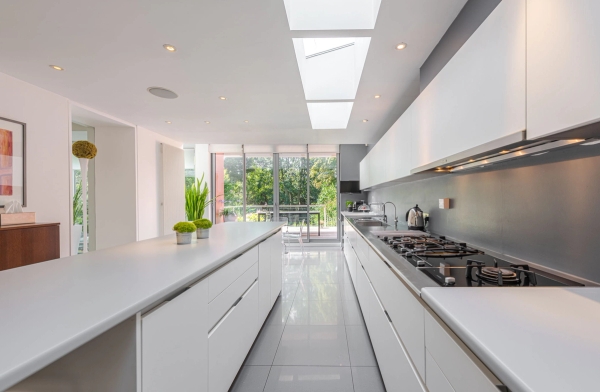 Sleek contemporary kitchen interior with long white countertops and polished flooring, perfect for premium culinary product filming, Love Locations W4.