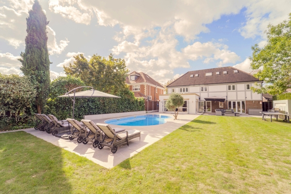 Wide lawn garden view featuring an outdoor pool, sun loungers, and mature estate trees, Love Locations RM11.