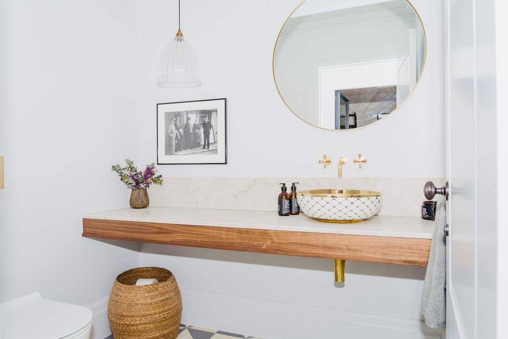 Bathroom vanity featuring a timber countertop, vessel sink, brass taps, and round mirror, Love Locations TW11.