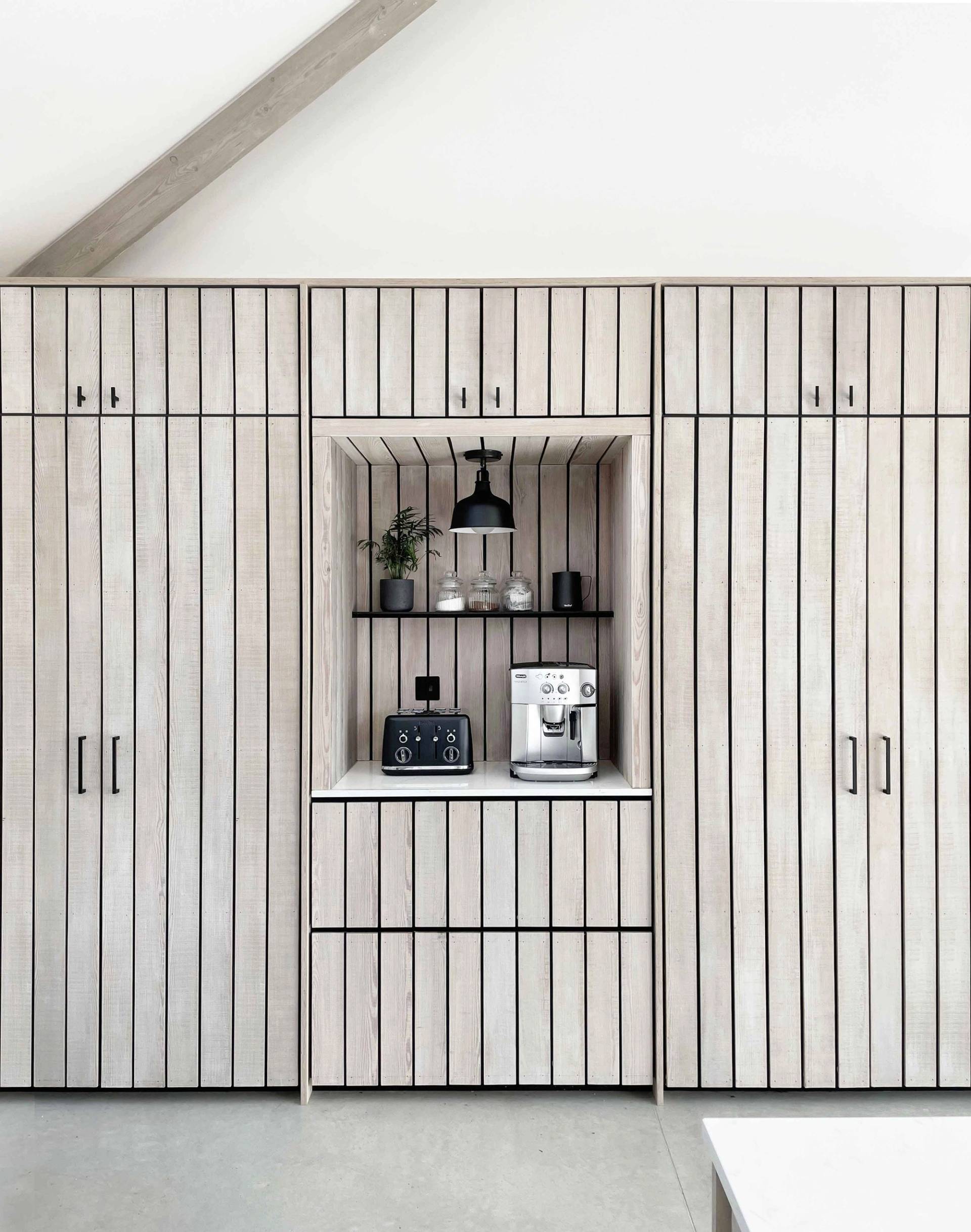 Integrated breakfast pantry bar concealed behind slatted timber doors in a modern Scandi kitchen, ideal for home appliance advertising, Love Locations PO18.