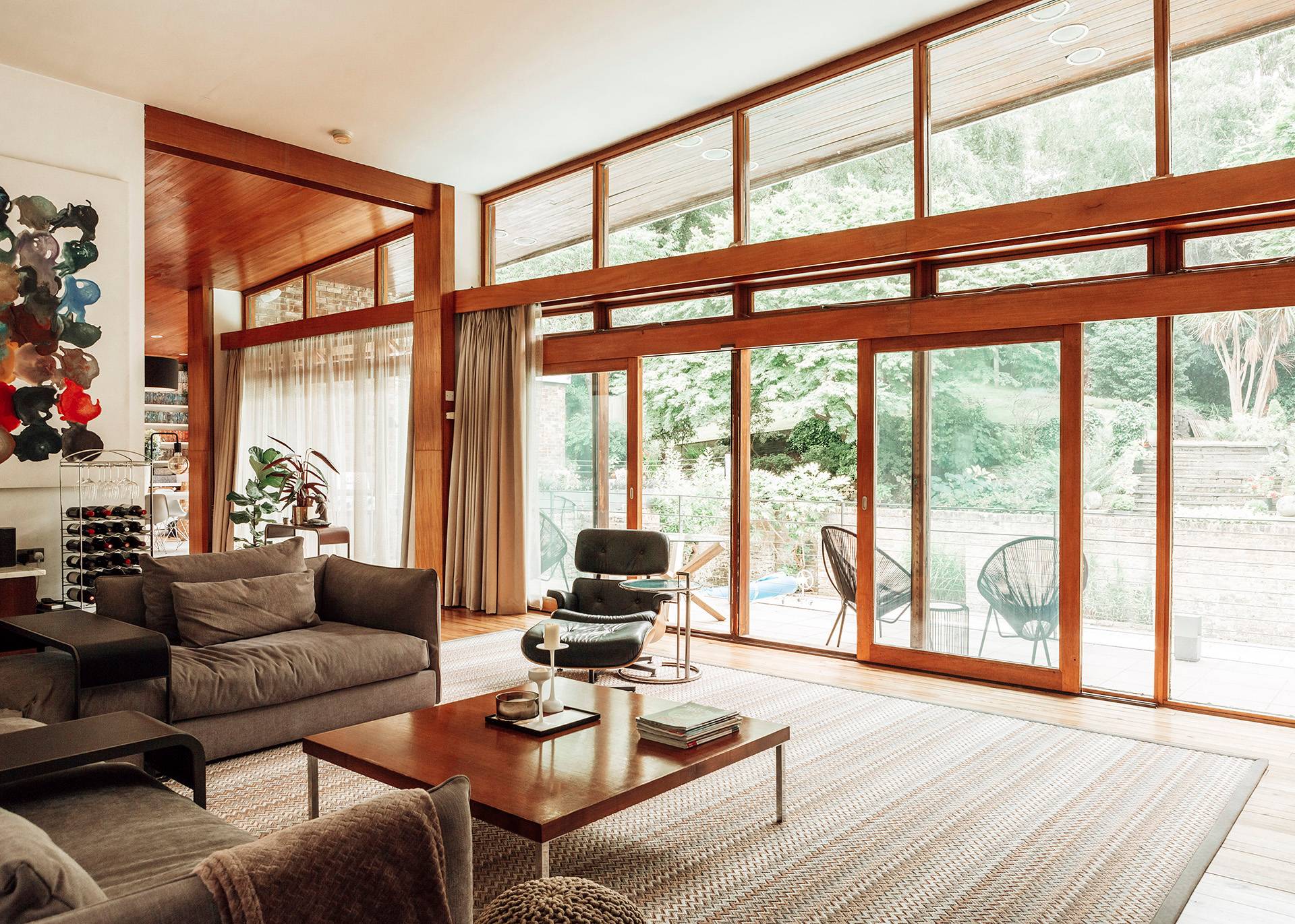 Floor-to-ceiling glass patio doors in a mid-century modern Bromley home opening to an outdoor deck, Love Locations.