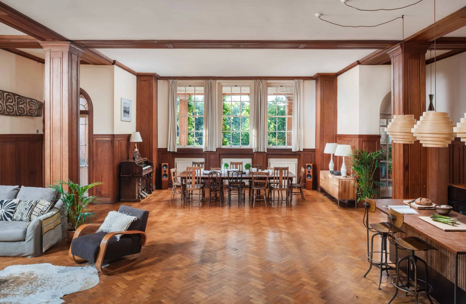 Grand wood-panelled dining hall film location in Ipplepen Totnes Devon TQ12 by Love Locations, featuring long dining tables, large multi-pane windows, and polished parquet floors