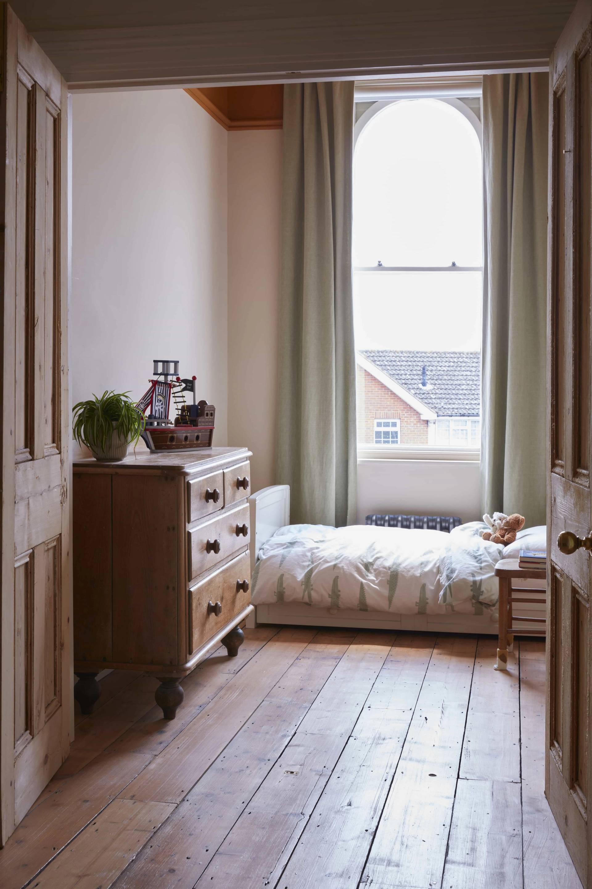 Character bedroom corner with a wooden chest of drawers set between open timber doors, Love Locations TN34.