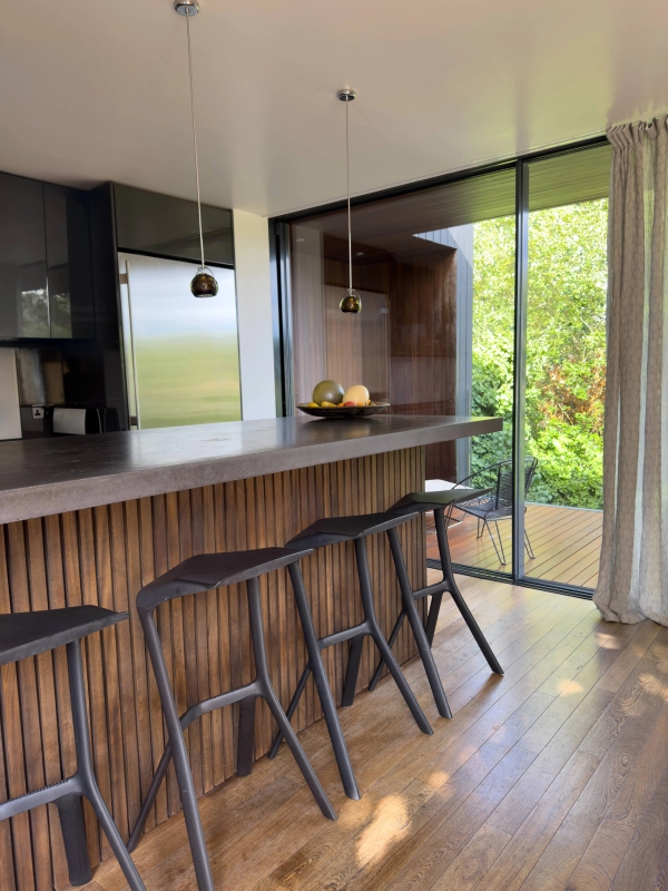 Modern kitchen with island at Love Locations Highgate Zen home, featuring sleek design and appliances.