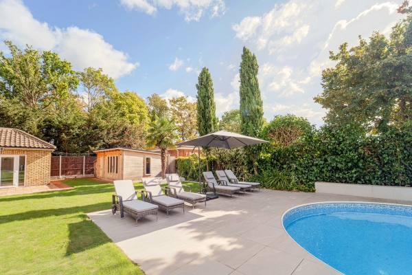Outdoor swimming pool terrace with luxury wooden sun loungers and sun parasols, Love Locations RM11.