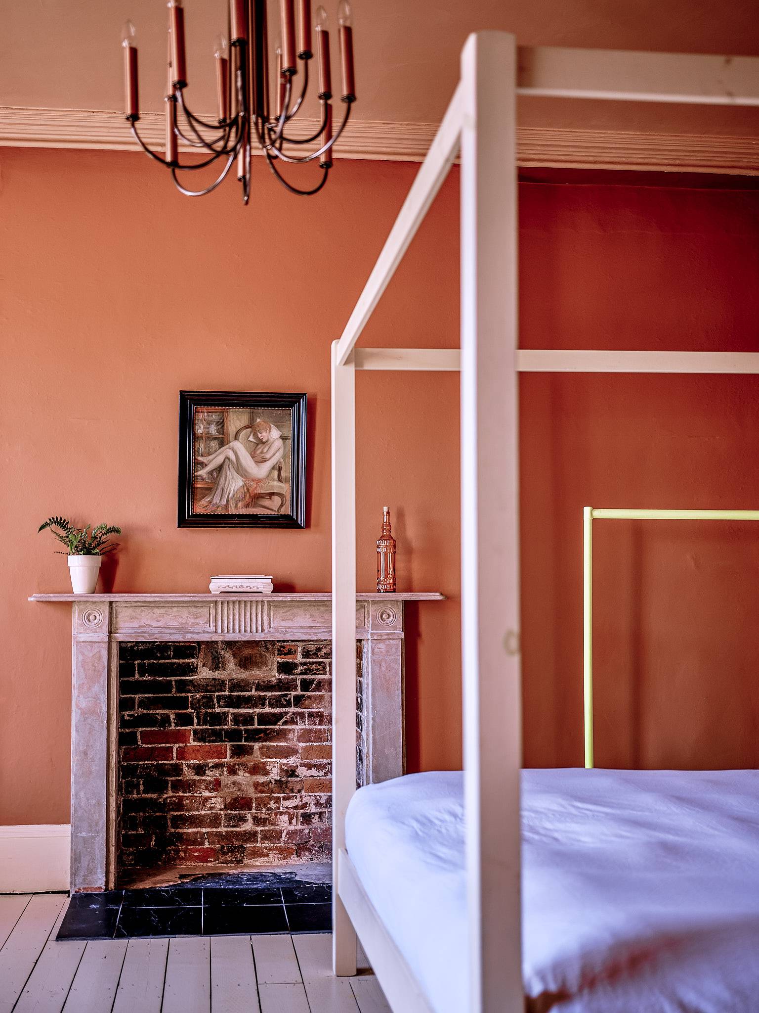 Terracotta bedroom view showing a four-poster bed, brick fireplace alcove, and framed artwork, Love Locations ME13.