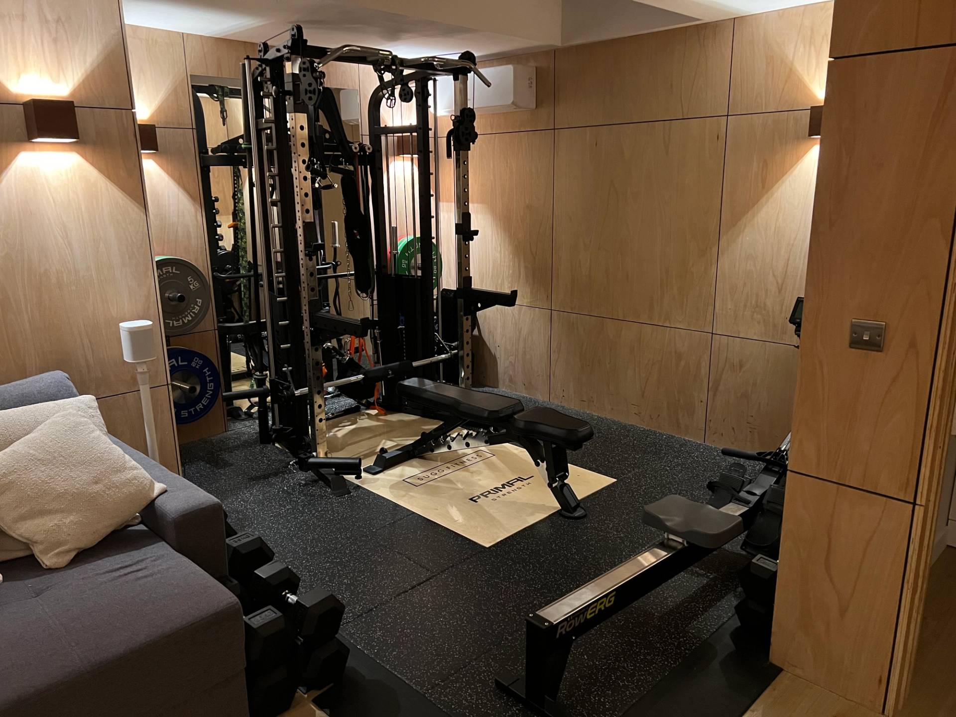 Private home gym setup with commercial weightlifting rack and black rubber floor matting, Love Locations TW1.