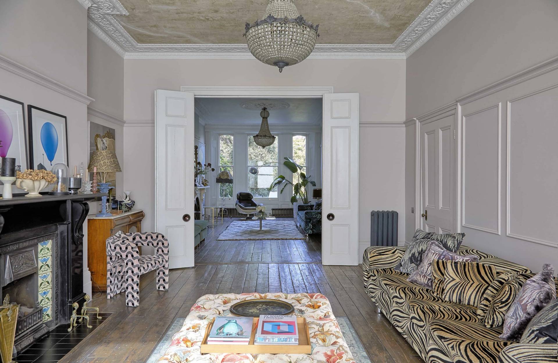 View looking through white double doors across double reception rooms with stripped wood floors and crystal lighting, Love Locations N16.