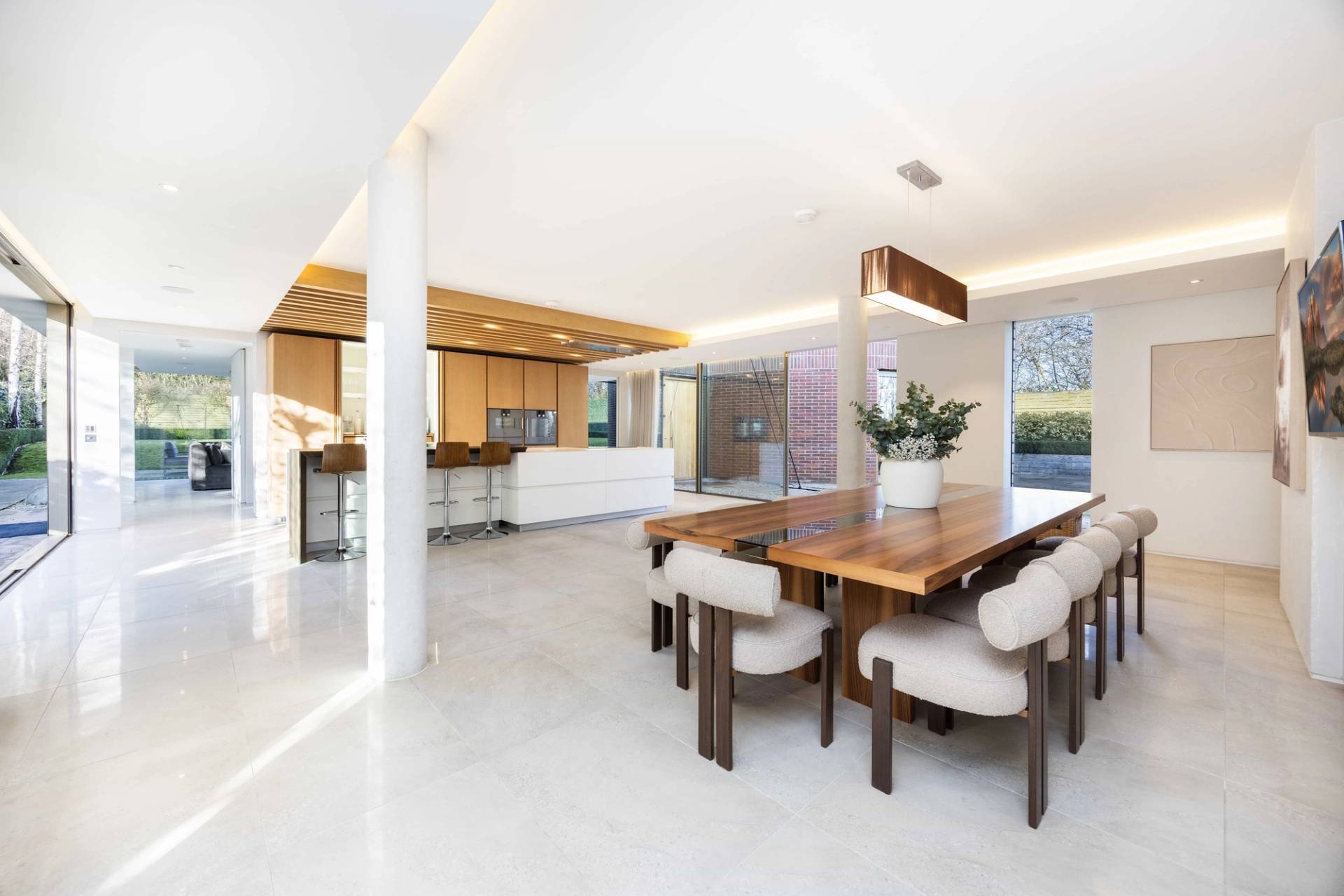 Open-plan living space in Radlett, WD7 connecting a modern dining suite to a slatted timber ceiling lounge, Love Locations.