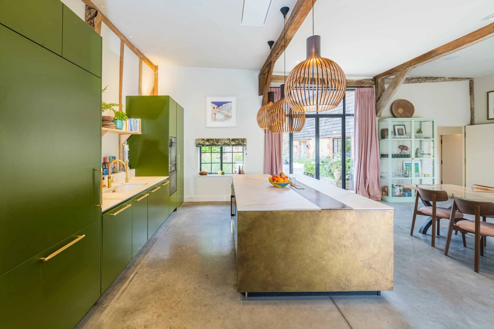 Olive green fitted kitchen corridor with a brass island counter and vaulted timber ceilings in West Sussex, Love Locations GU28.