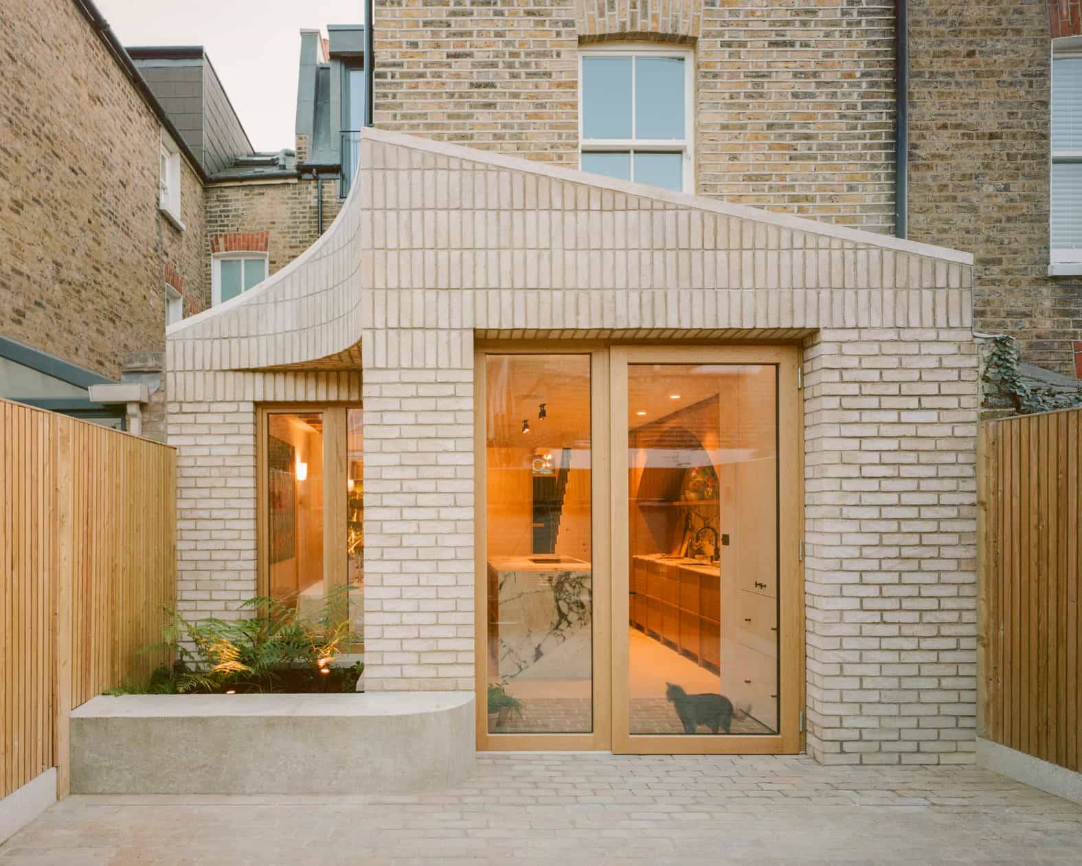 Architectural pale brick extension shoot location hero cover image in Clapham Common, SW4 featuring curved pale brick facade, oak pivot doors, green-veined marble arched kitchen, custom oak joinery, clay plaster bathrooms, and neutral plaster bedrooms, the ultimate high-visibility backdrop for feature film productions, TV commercials, high-fashion editorials, and luxury brand campaigns via Love Locations.