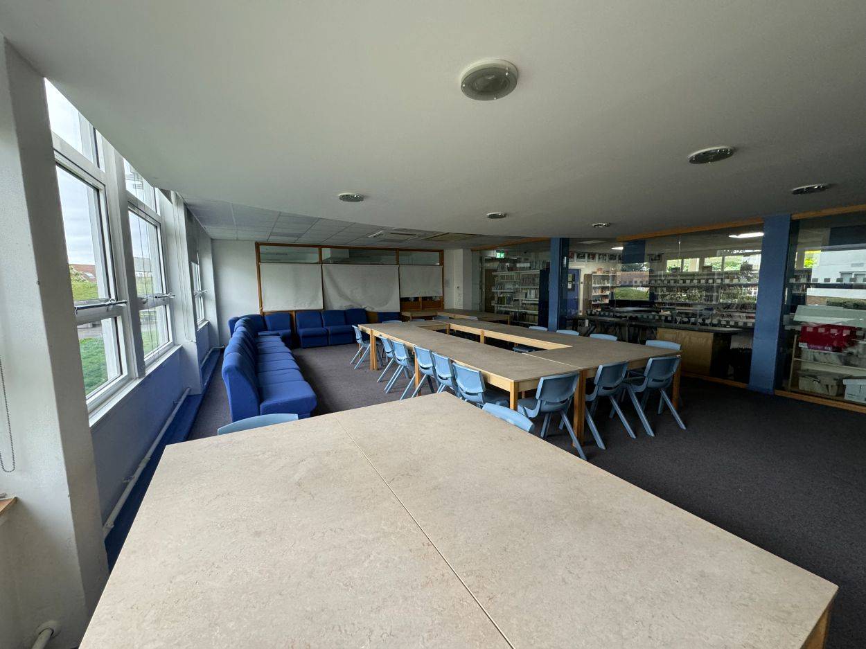 School library and learning resource center location house in North Finchley N12, with low study tables and blue perimeter seating via Love Locations.