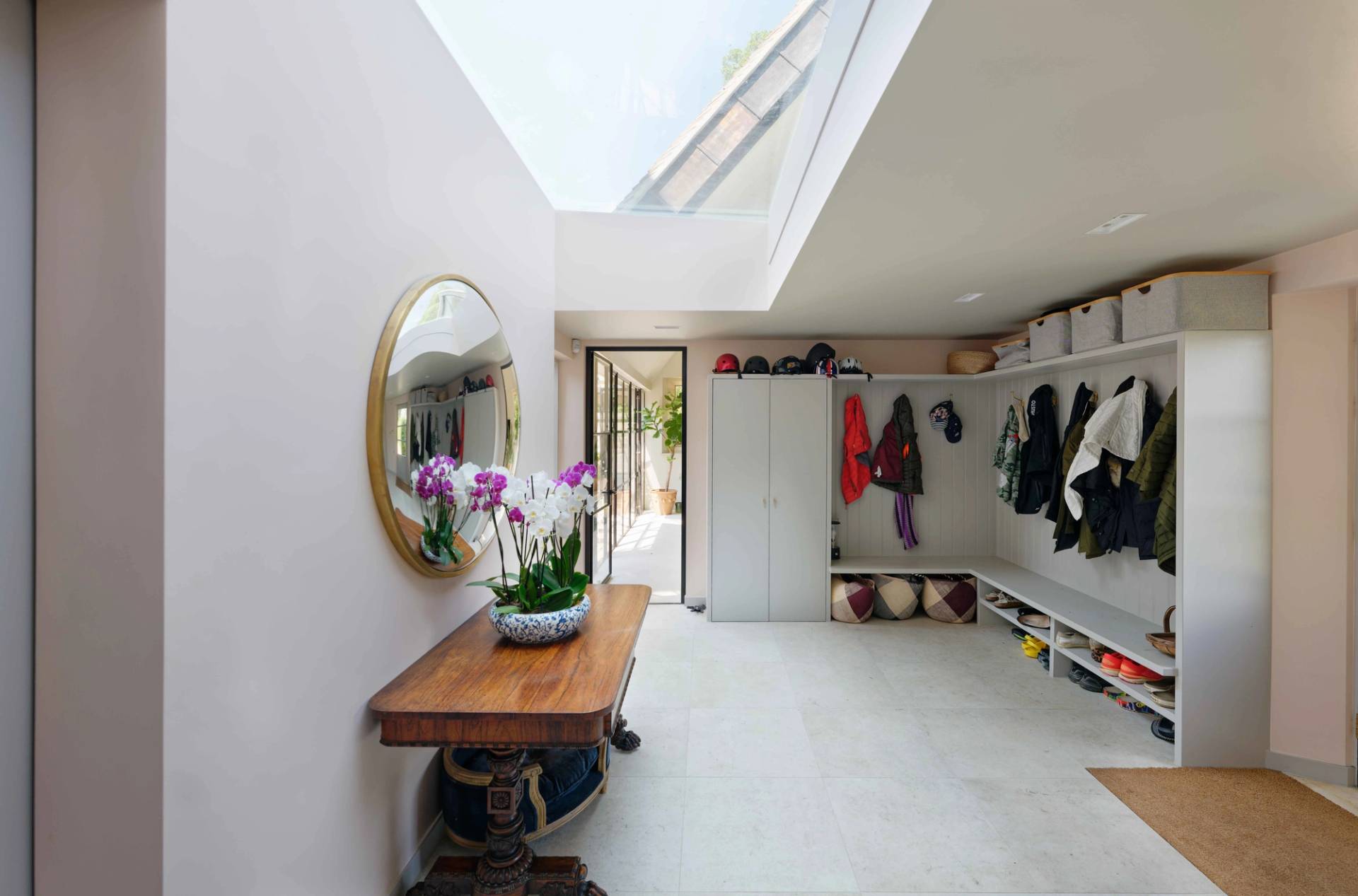 Entrance hallway transition featuring an oval wall mirror, wooden console table, and skylight, Love Locations OX7.