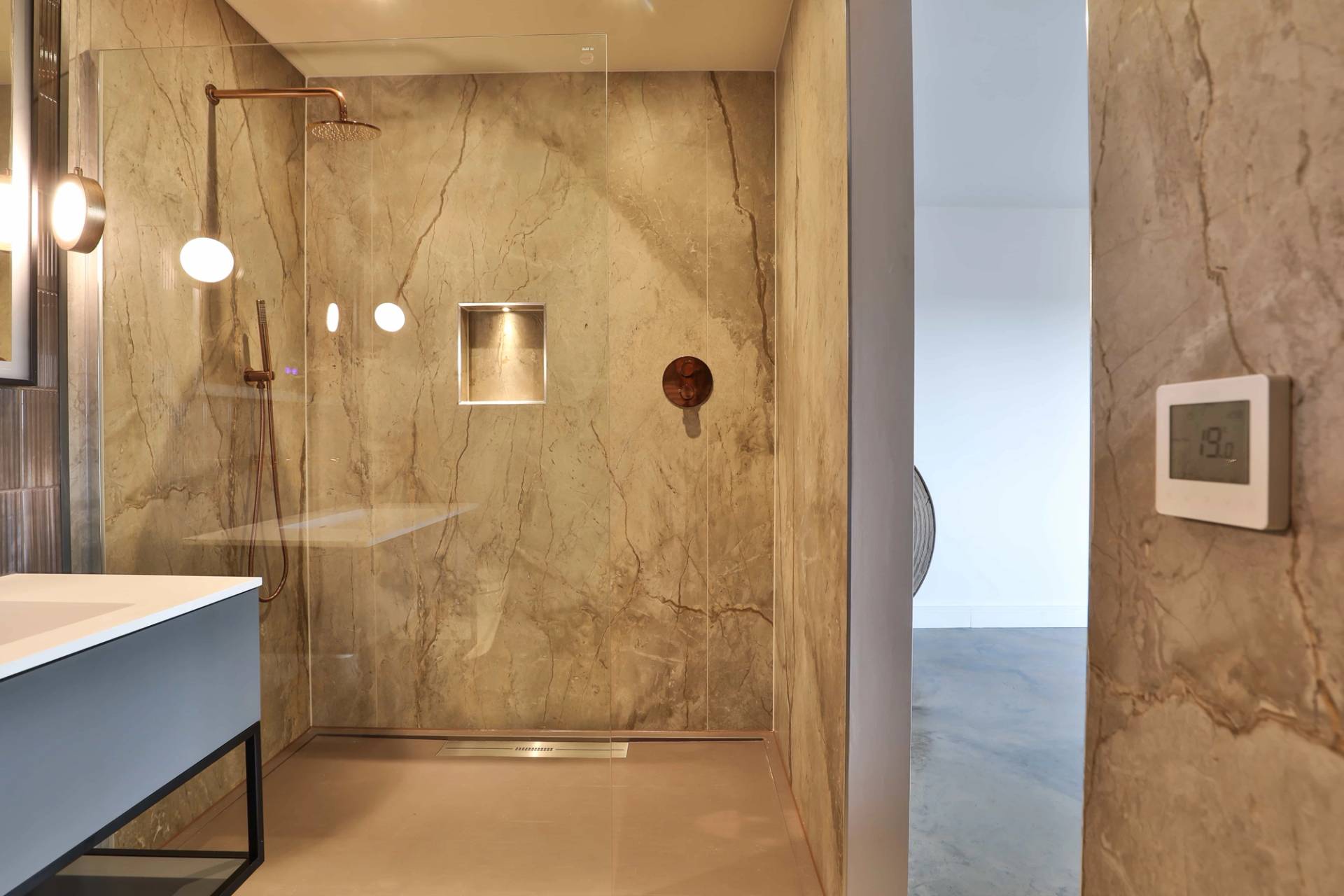 Walk-in wet room shower with marble-look wall tiles, rain shower head, and glass screen, Love Locations CV23.