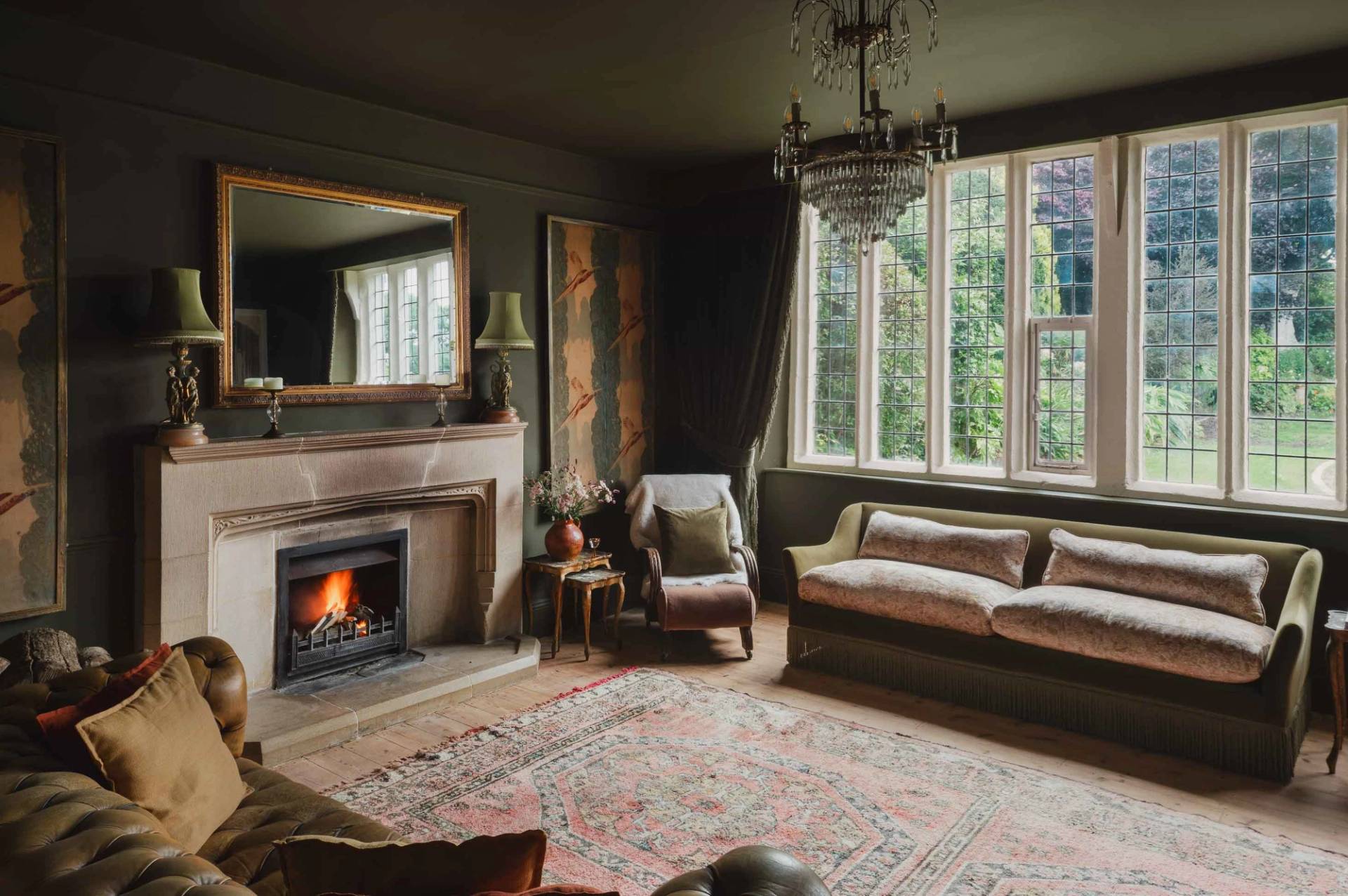 Period reception room with stone fireplace, green walls, and large sash window in Newquay Cornwall TR8 through Love Locations.