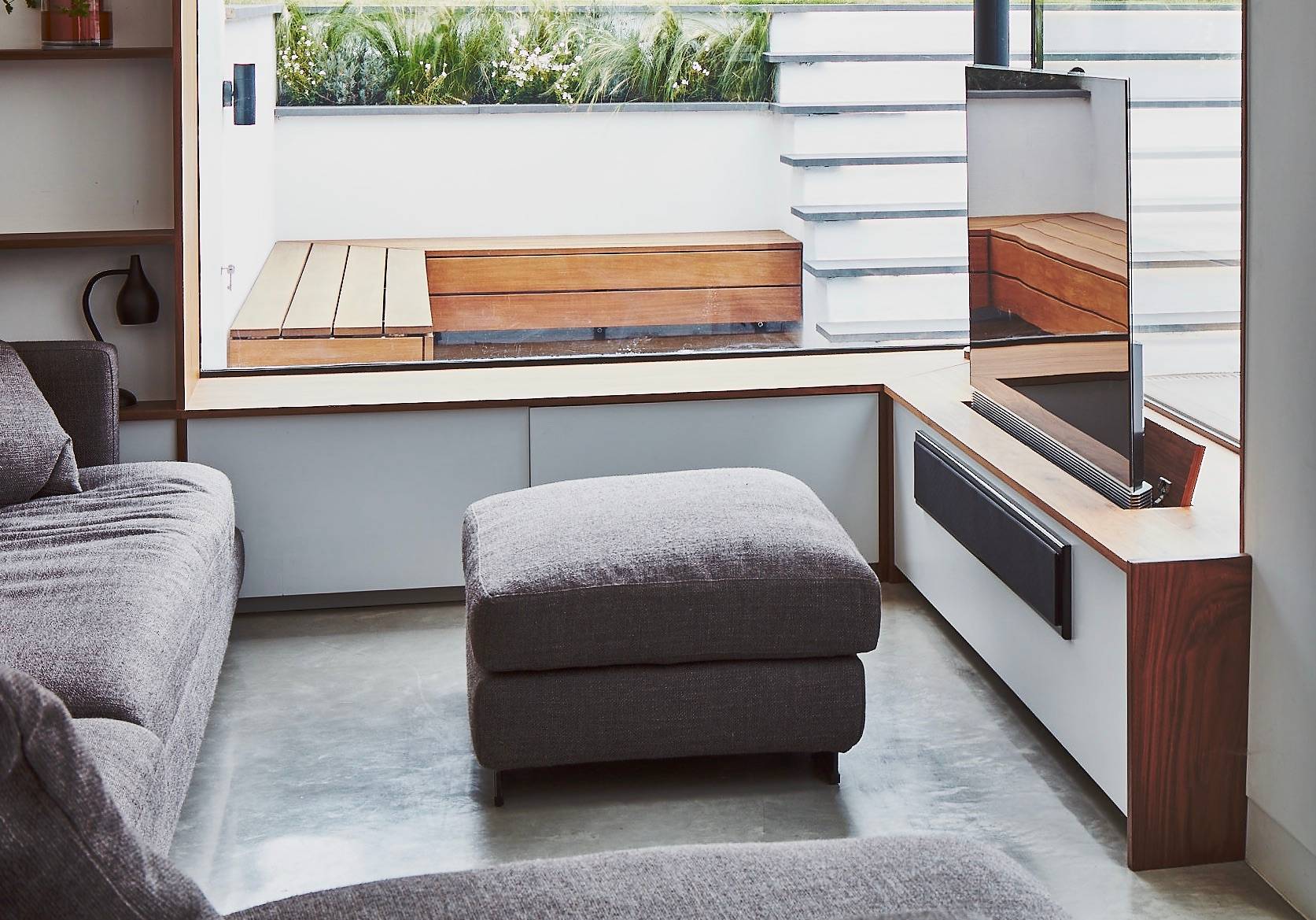 Sunken courtyard view looking onto a grey upholstered footstool and slate tiled floor, Love Locations TW1.